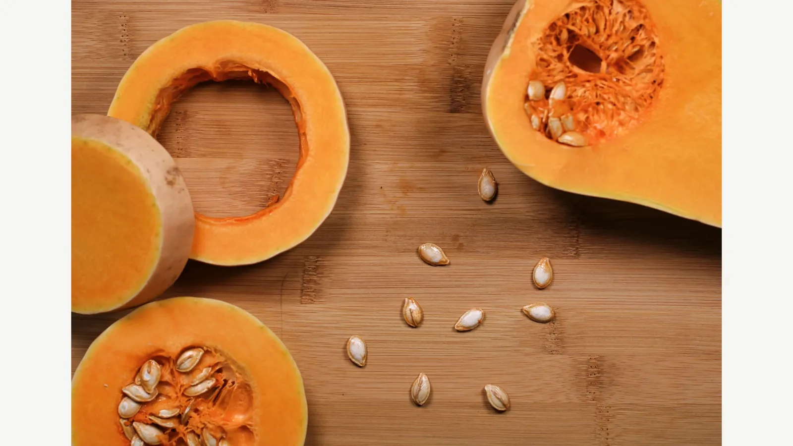 Cut pumpkin pieces on a wooden surface.