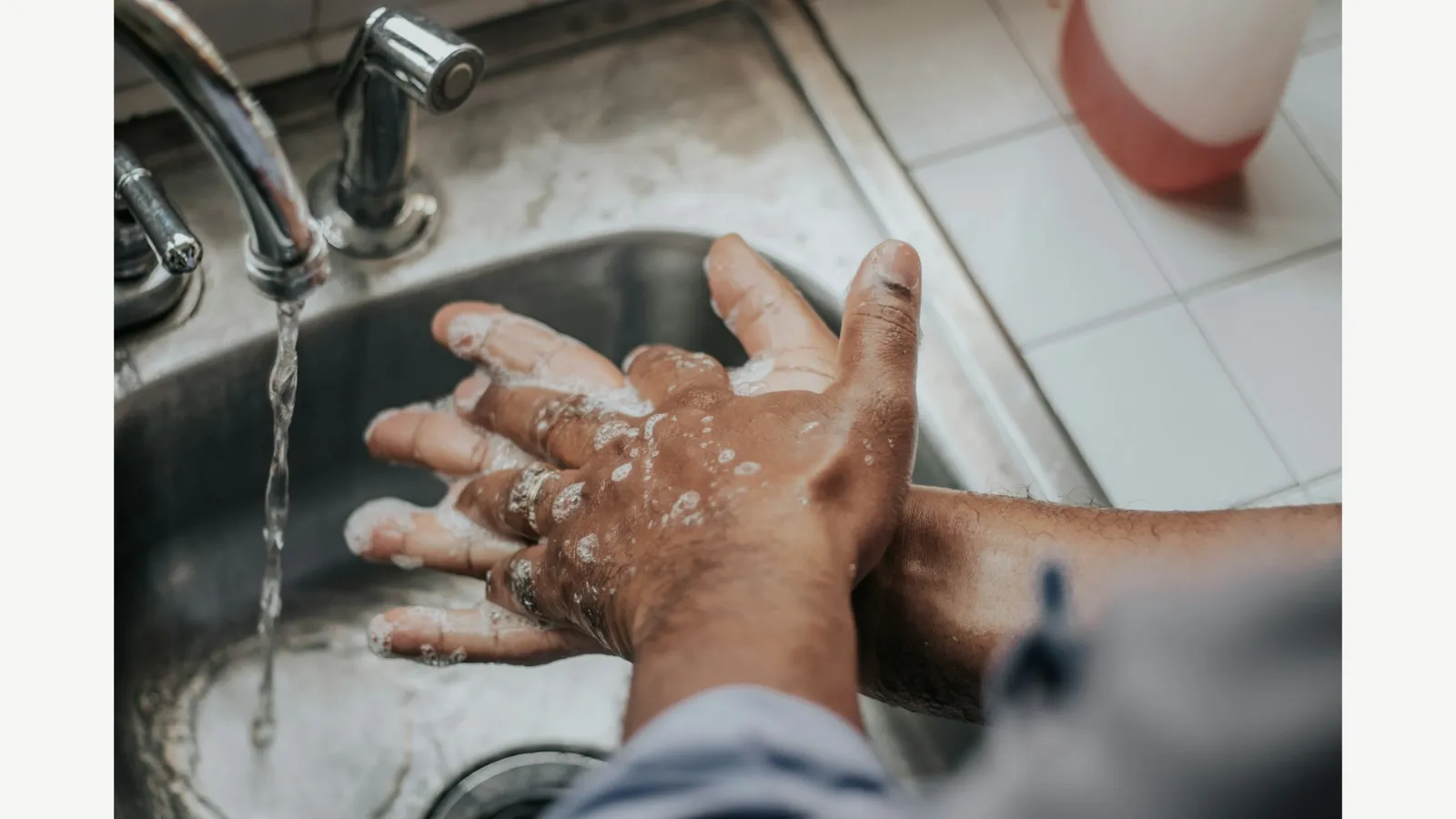 Hands being washed at a sink.