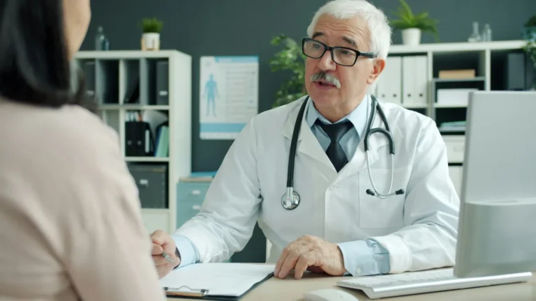 A doctor and patient talking across a desk.