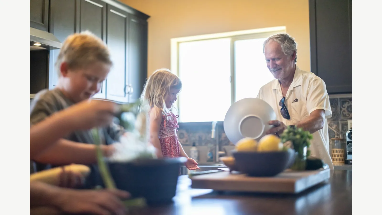 Family members preparing food together in a kitchen.