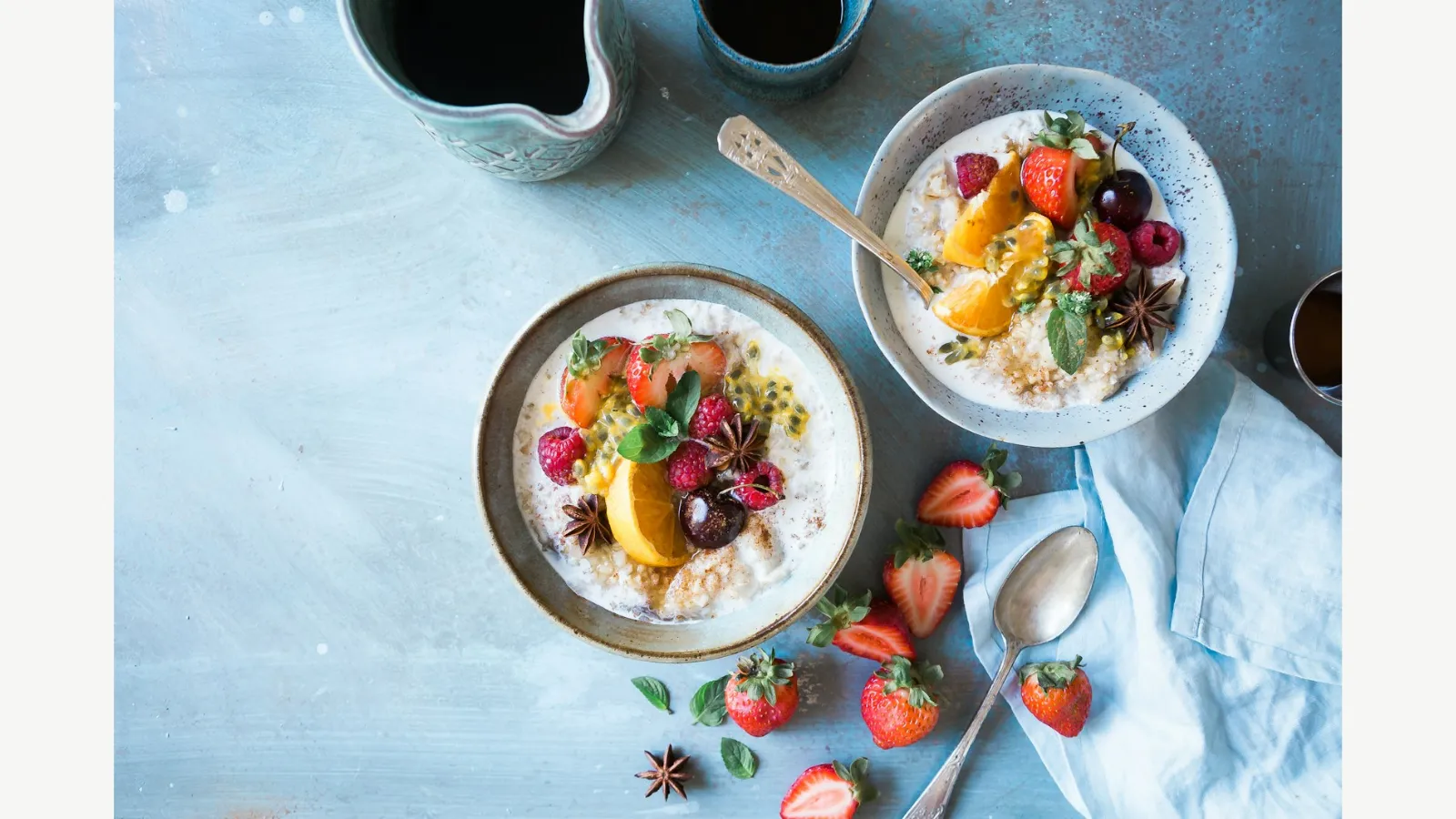 Bowls of oats with fruit on a breakfast table.