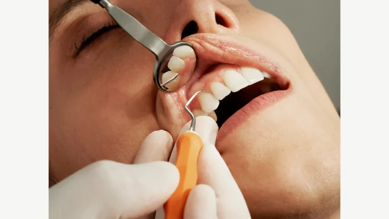 A dental professional examining teeth with a mirror and instrument.