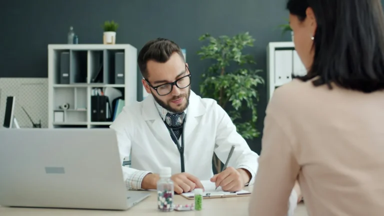 A doctor writing notes during a consultation.